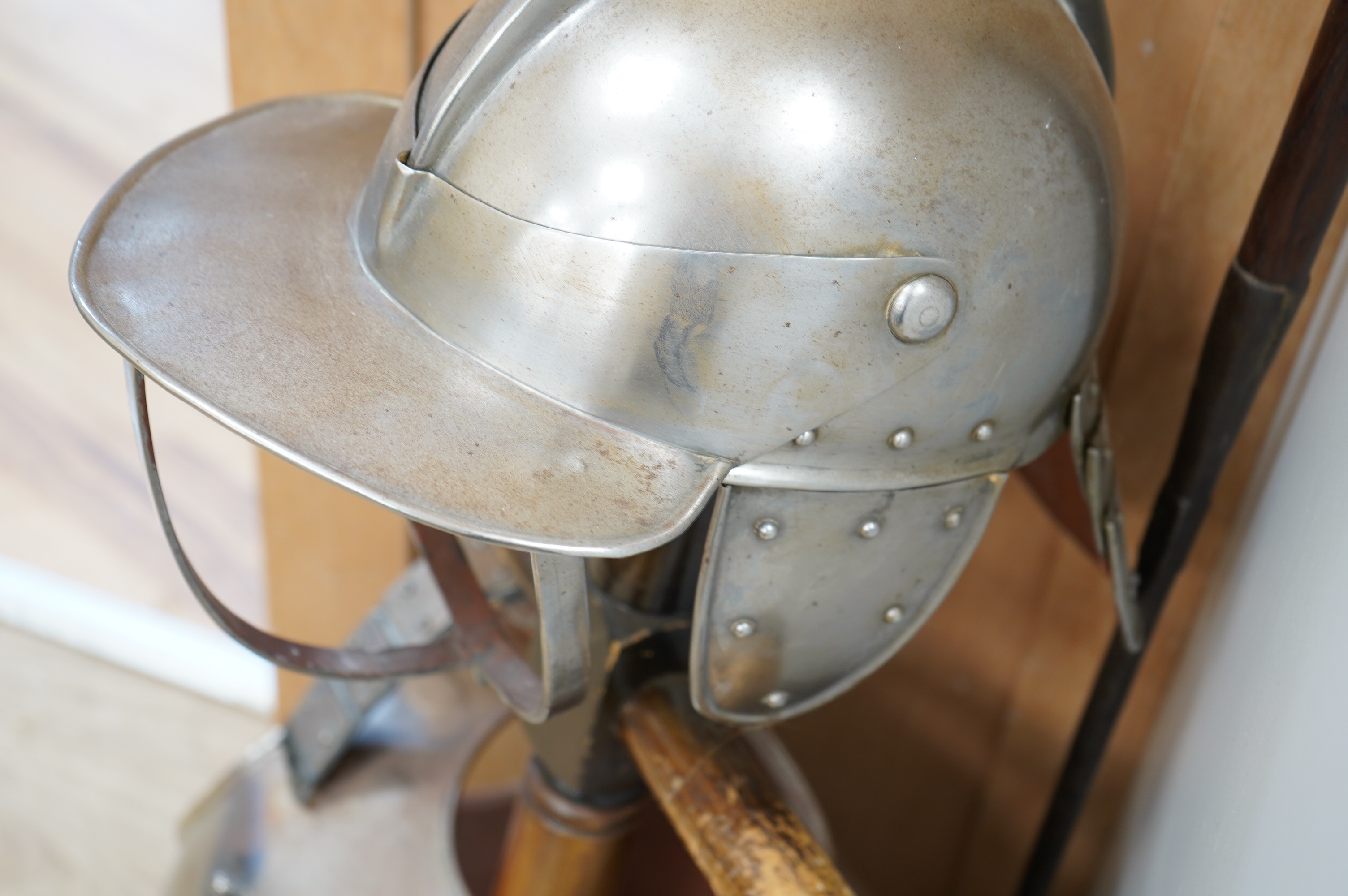 A replica suit of English Civil War armour on a stand, comprising; a lobster pot helmet, breastplate and back plate. Condition - poor to fair